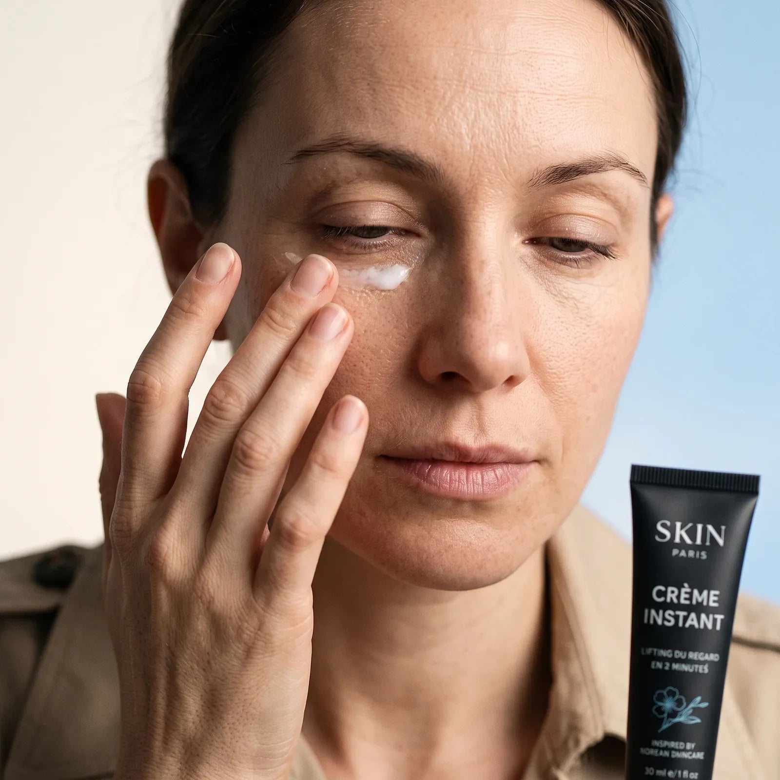 Une femme applique la crème sur son contour des yeux